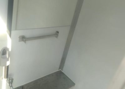 Interior of a Mobi-Shower portable shower stall showing stainless steel fittings