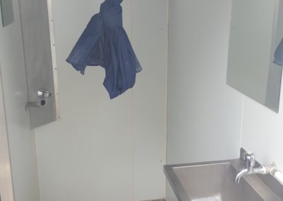 Interior of a Mobi-Shower portable shower stall showing stainless steel fittings