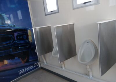 Interior of a Mobi-Shower portable shower stall showing stainless steel fittings