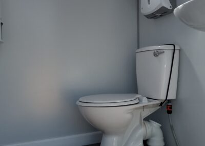 Interior of a Mobi-Shower portable shower stall showing stainless steel fittings